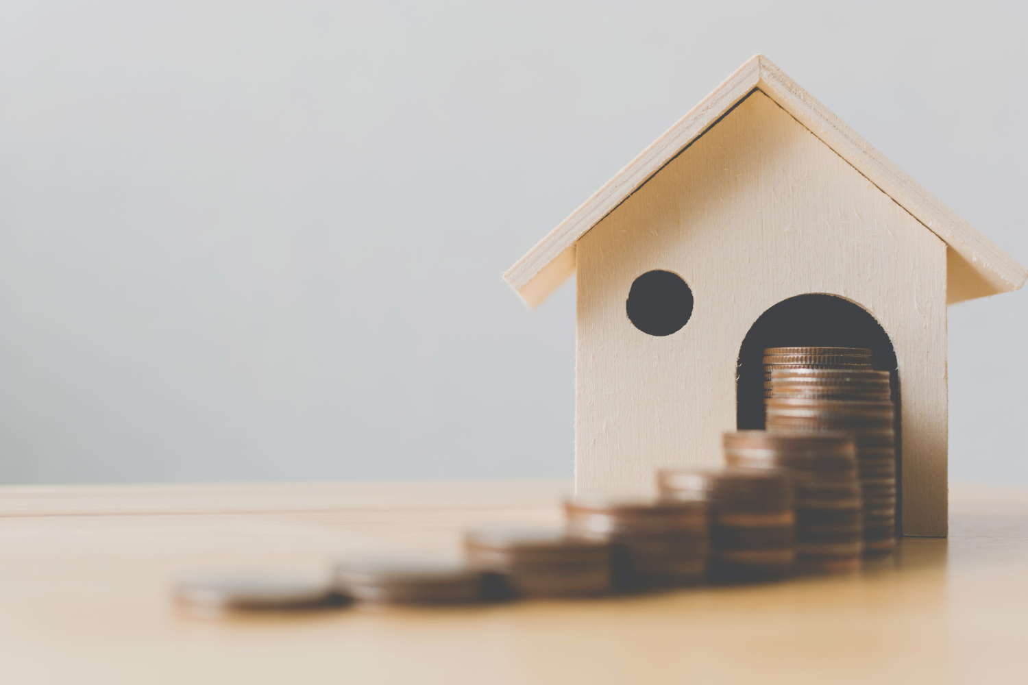 Concept financier d'investissement immobilier, pile de pièces d'argent avec maison en bois
